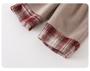 Gros plan d'un pantalon en polaire kaki avec revers à carreaux rouges et blancs