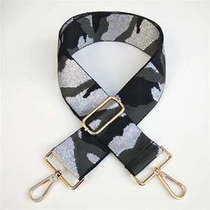 Detail of wide camo shoulder strap with gold metallic buckles and adjustable swivel hooks