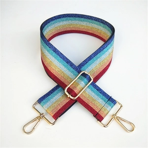 Close-up of rainbow striped woven bag strap with metallic shimmer and gold buckles