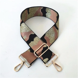Macro detail of thick camo shoulder strap with pink glitter and gold metal lobster clasps