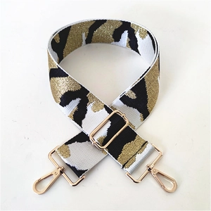 Close-up of wide leopard print woven shoulder strap with gold metal adjustment buckle