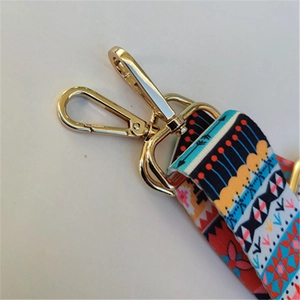 Close-up of ethnic style fabric strap featuring colorful patterns and a gold metal swivel hook
