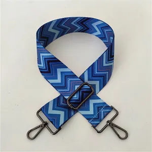 Detail of adjustable woven bag strap with blue zigzag pattern and gunmetal clasp