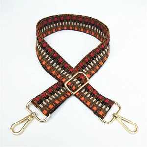 Detail of colorful ethnic weave pattern with golden metal buckles on wide bag strap