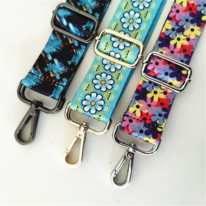 Detail view of three colorful adjustable shoulder straps with floral patterns and lobster clasps