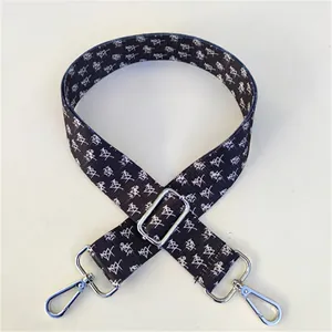 Detail of adjustable strap with geometric pattern and silver metal swivel hooks