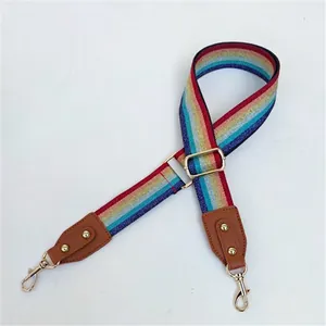 Adjustable rainbow striped bag strap with brown leather ends and gold metal hooks