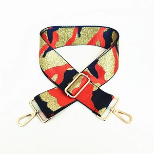 Close-up of red and blue camouflage pattern bag strap with gold metal buckle