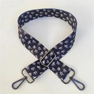 Close-up of black and white patterned bag strap with durable gun-metal swivel hooks
