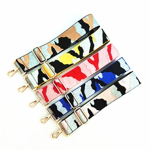 Detail view of five wide camouflage patterned purse straps with gold metal clasps