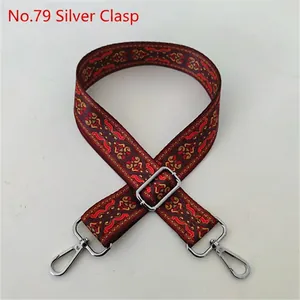 Close-up of wide ethnic woven strap with red yellow patterns and silver metal hooks
