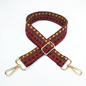 Close-up of wide ethnic woven strap with geometric pattern and golden alloy hooks