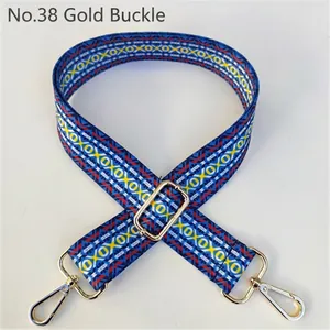 Detail of blue jacquard guitar strap with geometric patterns and gold metal buckle