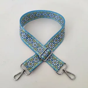Detail of blue daisy pattern wide replacement bag strap with silver metal lobster clasps