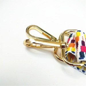 Detail showing the gold metal lobster clasp and colorful woven ethnic pattern bag strap