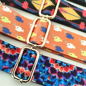 Detail of colorful woven shoulder straps with golden metal buckles in various patterns