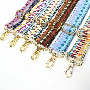 Close-up of colorful geometric woven bag straps with gold metal swivel hooks and buckles