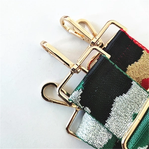 Detail of wide ethnic style embroidered strap with gold lobster clasps and camouflage pattern