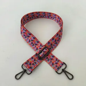 Detail of floral canvas bag strap featuring colorful patterns and gunmetal swivel hooks