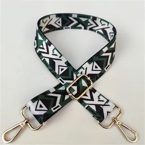 Detail of adjustable wide shoulder strap featuring ethnic green geometric patterns and gold buckles