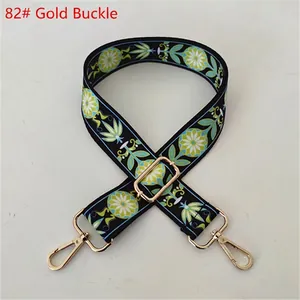Close-up of ethnic style wide fabric shoulder strap with floral pattern and gold metal hooks