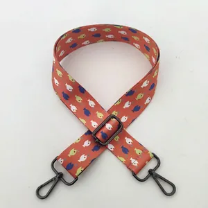 Detail of adjustable colorful shoulder strap with fish pattern and gunmetal clasp