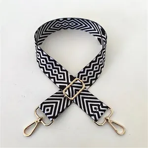 Close-up of number 98 black and white geometric wide bag strap with gold metal buckles