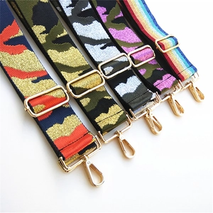 Detailed view of adjustable wide woven bag straps with camo patterns and gold hardware