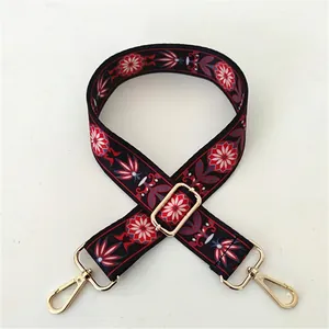 Close-up of ethnic floral embroidery strap with gold lobster clasps and buckles