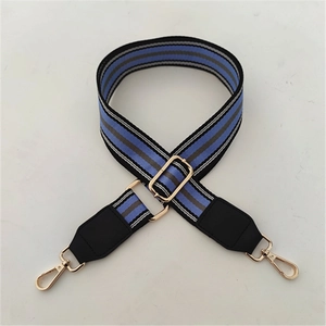 Detail of adjustable blue and gray striped nylon strap with gold lobster clasps