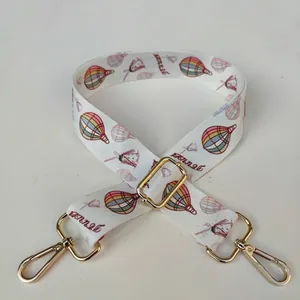 Detail of adjustable wide shoulder strap with hot air balloon print and gold hardware