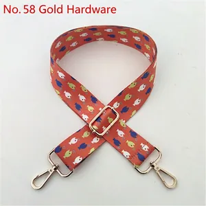 Close-up of ethnic adjustable bag strap with orange fish pattern and golden metal hooks