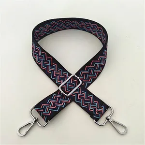 Close-up of ethnic style woven bag strap in black and blue geometric pattern with silver buckle
