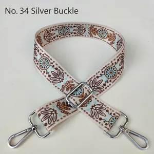 Close-up of bohemian style woven bag strap with blue floral pattern and silver buckle