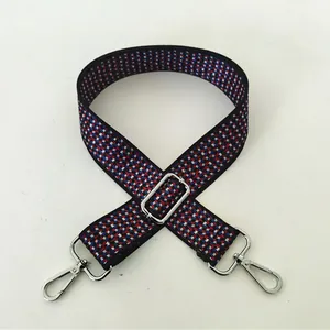 Close-up of Style 100 woven bag strap with red and blue geometric patterns and silver buckles