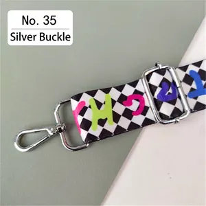 Detail of checkered bag strap with colorful graphic prints and silver lobster clasps