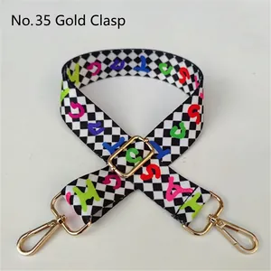 Detail of adjustable checkerboard bag strap with colorful letters and gold metal hooks