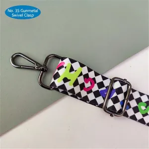 Detail of checkered strap with colorful letters and gunmetal gray lobster clasp hardware