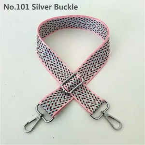 Close-up of pink and teal woven bag strap with V-shaped pattern and silver buckle