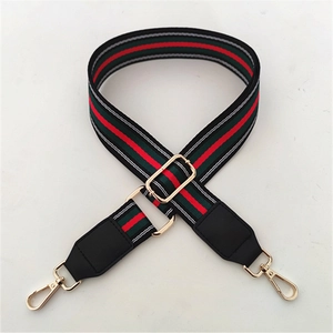 Detail of adjustable red and green striped bag strap with gold metal hooks and leather ends