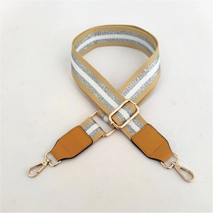 Détail de la bandoulière marron avec rayures pailletées argentées et crochets dorés