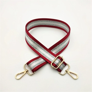 Detail of red and silver striped bag strap with premium gold metal swivel hooks and buckles