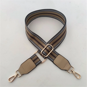 Detail of adjustable canvas strap with coffee brown stripes and gold metal swivel hooks