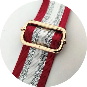 Détail de la bandoulière ajustable rayée rouge et blanc avec boucle en métal doré