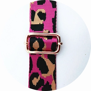 Gros plan sur la bandoulière léopard rose avec boucle de réglage en métal doré