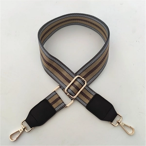 Detail of adjustable striped canvas strap with leather ends and gold metal snap hooks