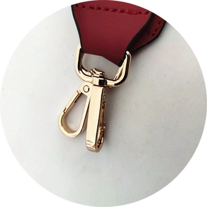 Détail de la bandoulière en cuir rouge avec mousqueton pivotant en métal doré
