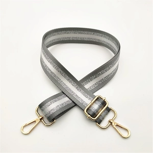 Detailed view of adjustable striped strap with silver glitter and gold lobster clasps
