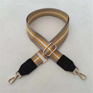 Detail view of adjustable striped canvas strap with leather ends and gold metal hooks