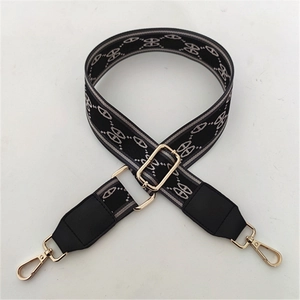 Detail of adjustable black and grey geometric strap with golden hooks and leather ends